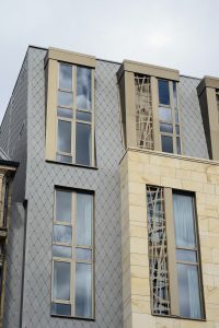 Zinc shingles and stone cladding mansard roof